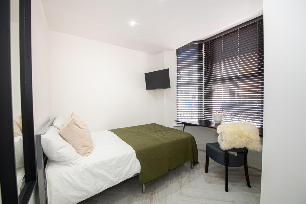 A bright and modern master bedroom featuring a ...