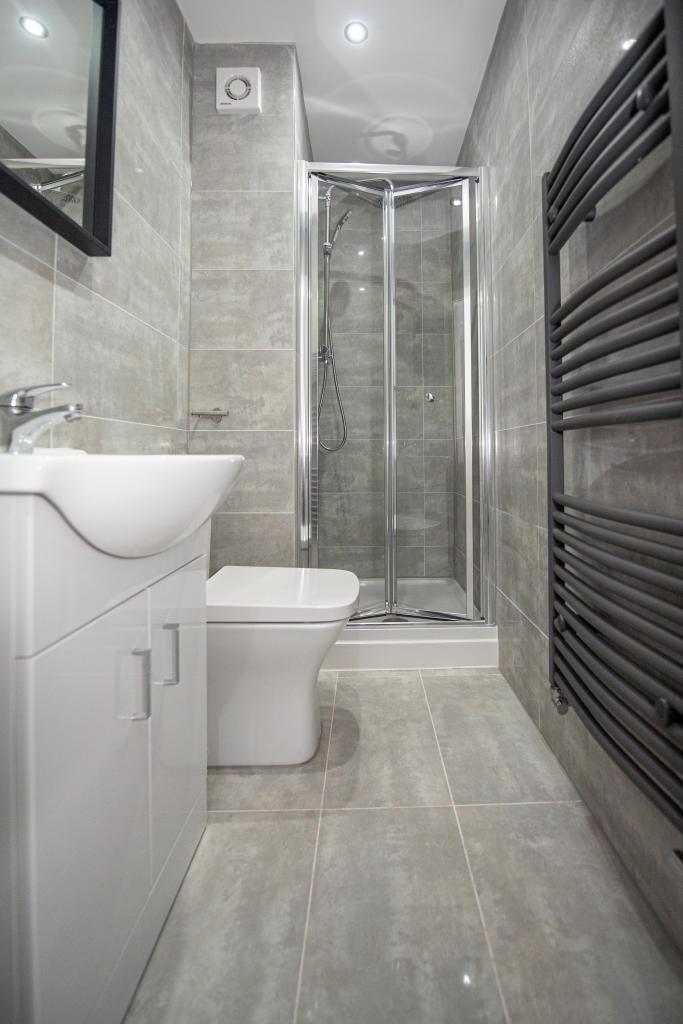 A modern, clean bathroom featuring a walk-in sh...