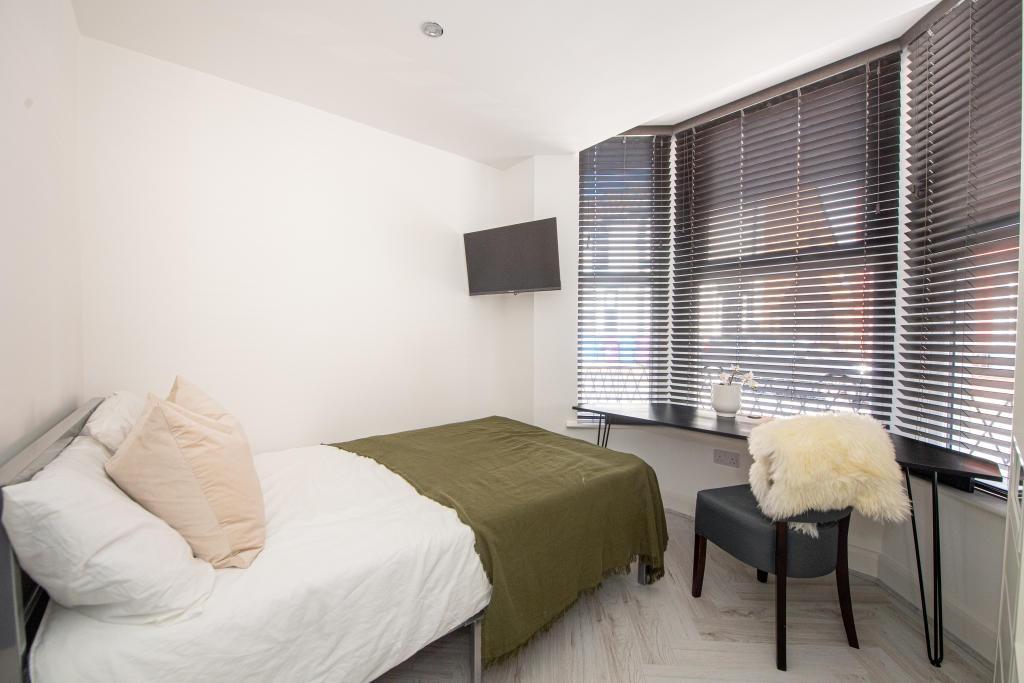 Bright and modern master bedroom featuring a co...