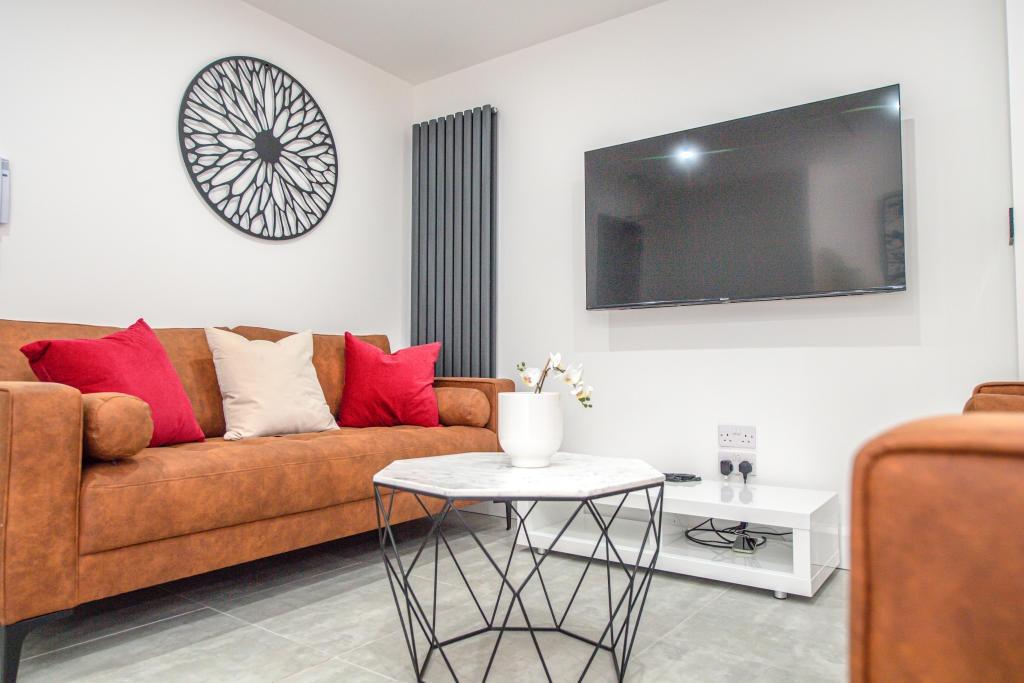 A spacious and modern living room featuring a c...