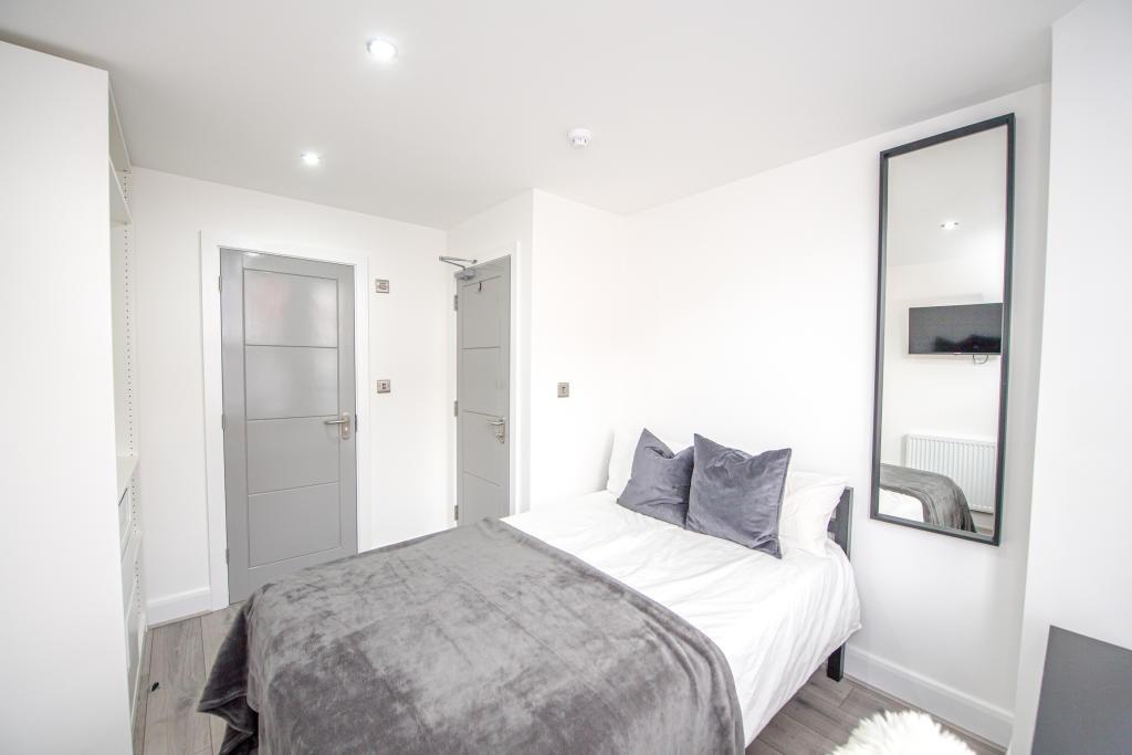 A bright and modern master bedroom featuring a ...