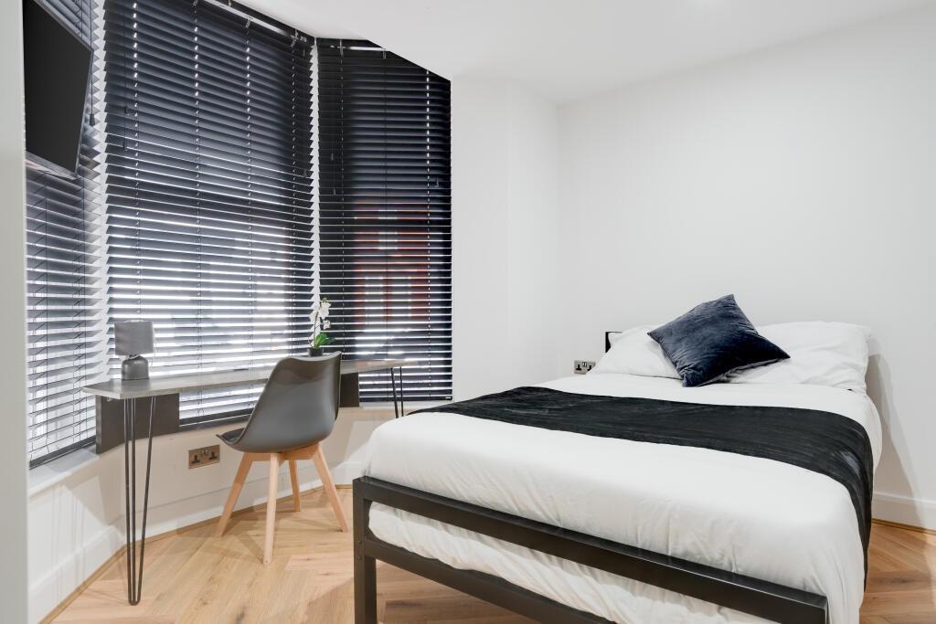 A clean and modern student bedroom featuring a ...