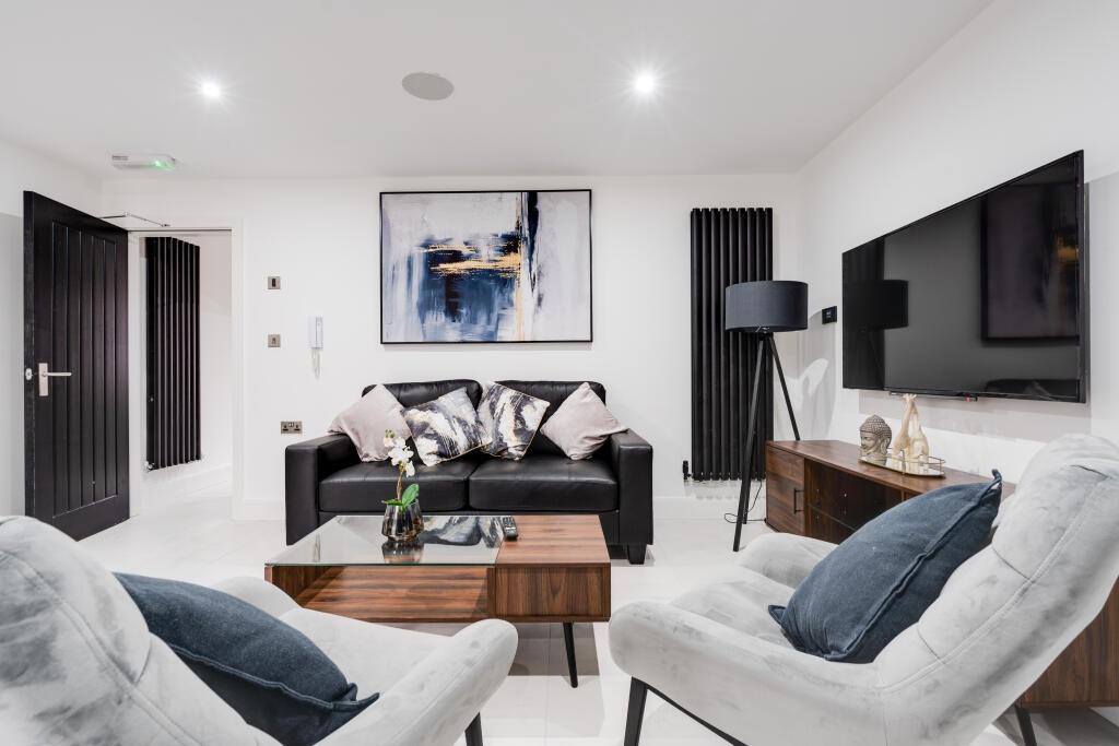 A modern, well-lit living room featuring comfor...