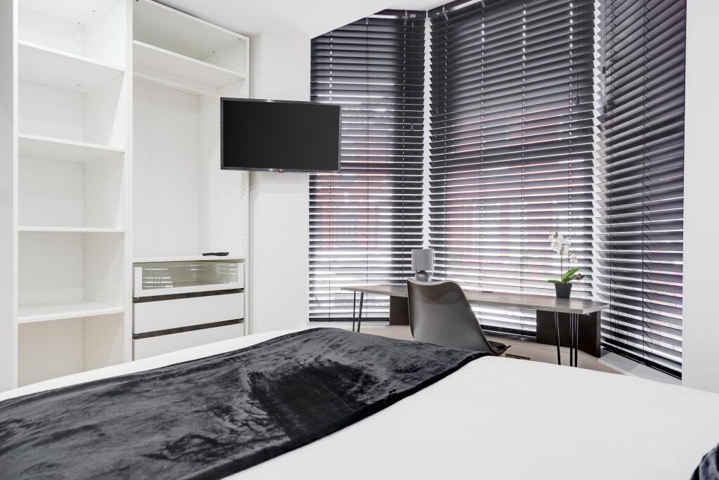 A modern bedroom featuring a large window with ...