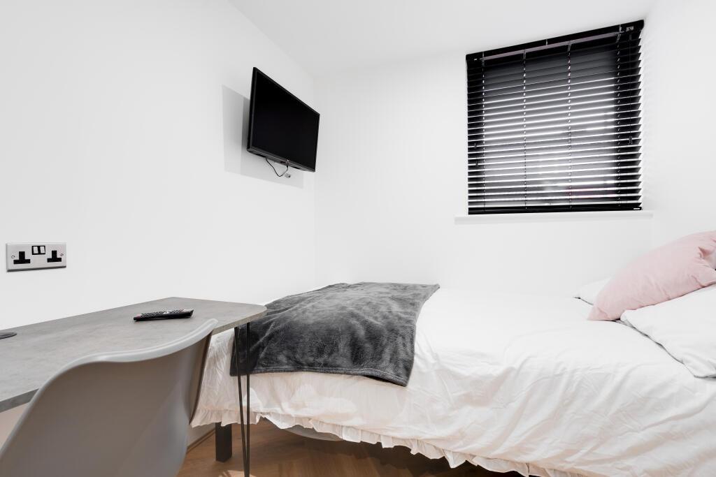 A cozy and well-maintained bedroom featuring a ...