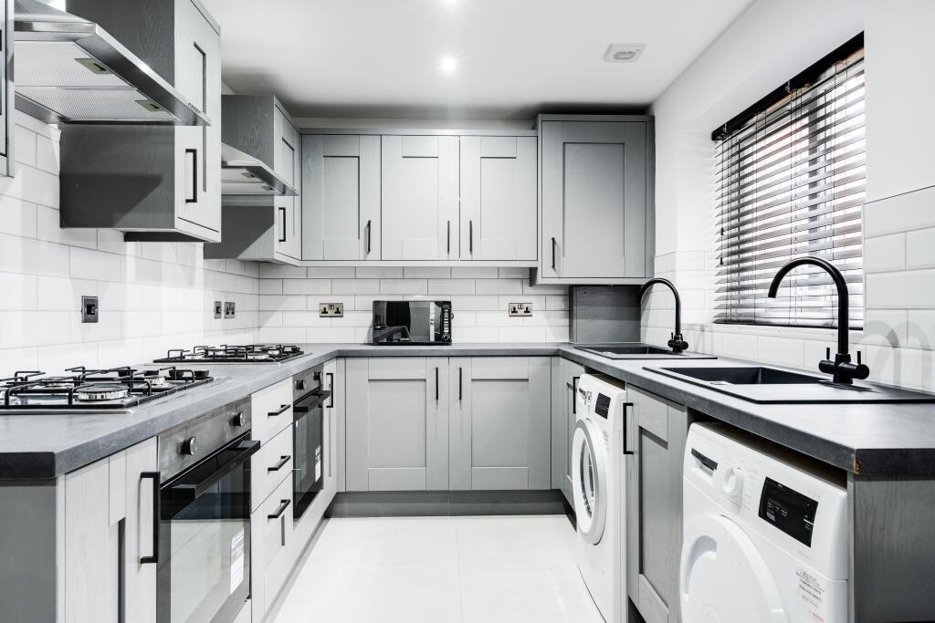 A bright and modern kitchen featuring ample cab...