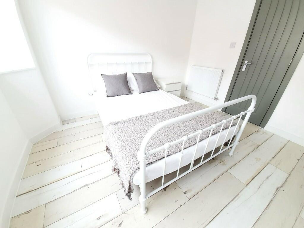 A bright and pristine single bedroom featuring ...