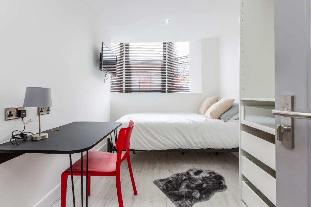 A spacious and well-lit master bedroom featurin...