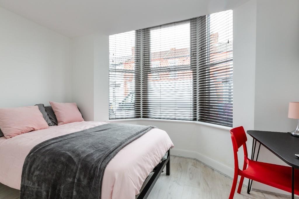 A bright and welcoming bedroom featuring a larg...