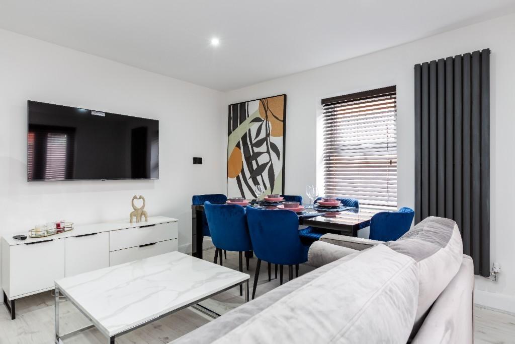 A modern, well-lit living room featuring a comf...