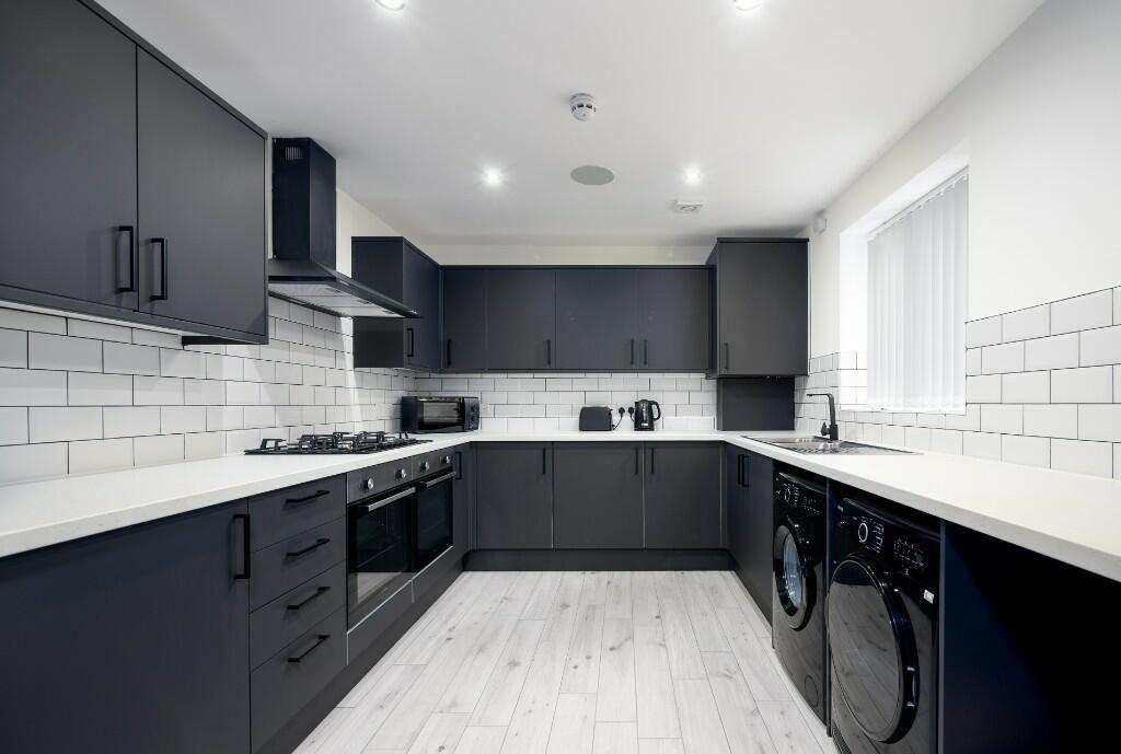 Modern and stylish kitchen featuring sleek dark...