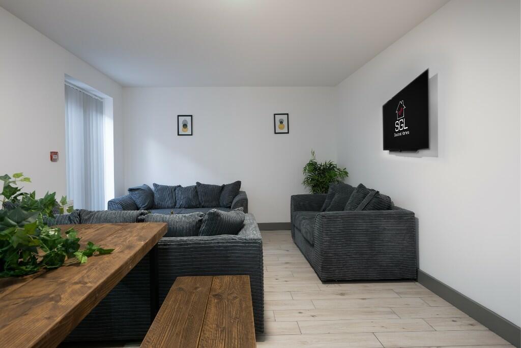 A modern, well-lit living room featuring comfor...