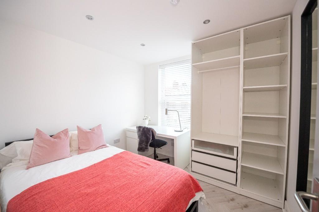 A bright and clean bedroom featuring a large be...
