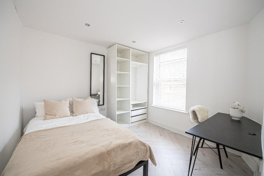 A bright and clean bedroom featuring a comforta...