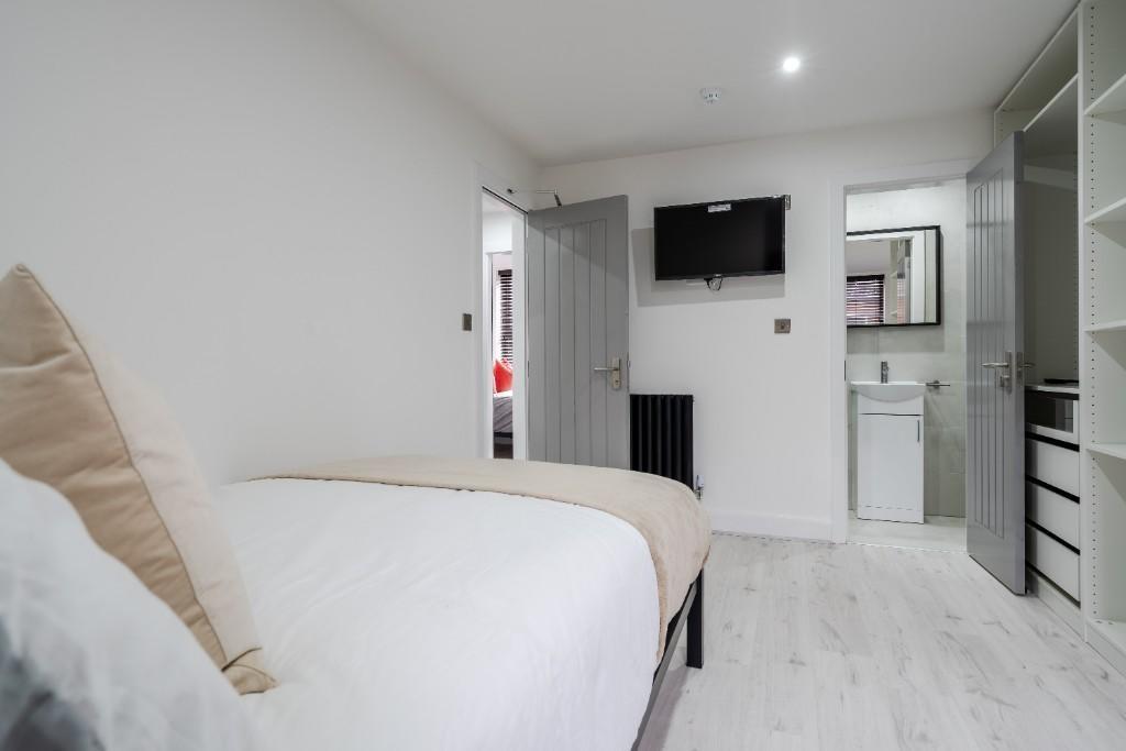 A bright, clean bedroom featuring a comfortable...