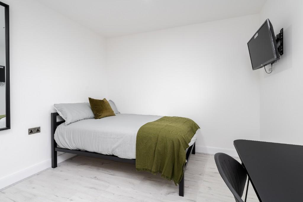 A bright and tidy double bedroom featuring a co...
