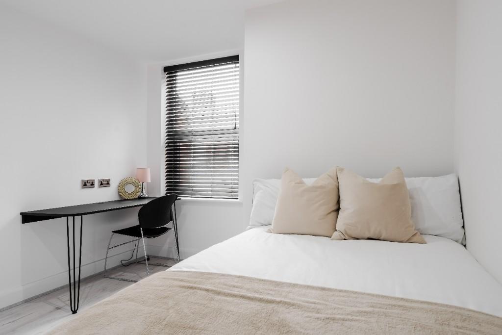 A clean and well-lit single bedroom featuring a...