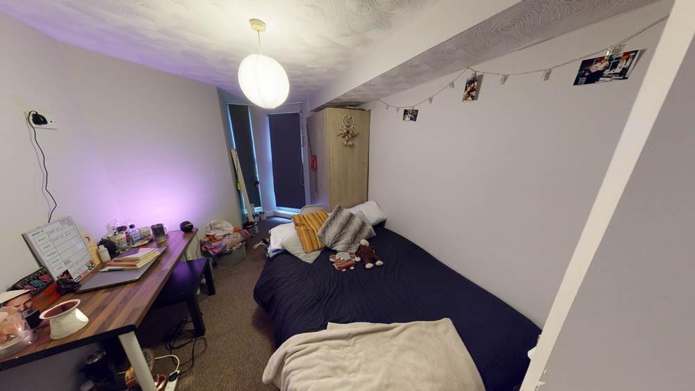 A cozy student bedroom featuring a single bed, ...