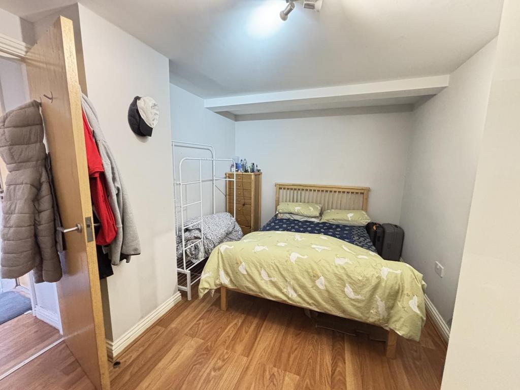 A cozy single bedroom featuring a neatly made b...