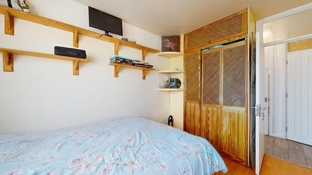 A cozy bedroom featuring a neatly made bed with...