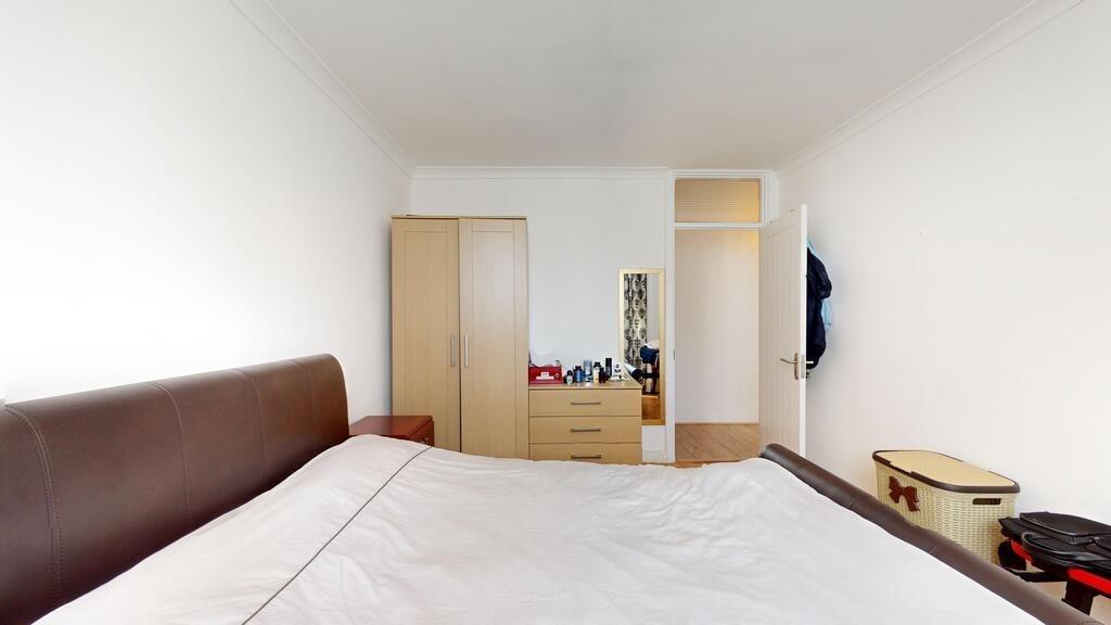 A bright and tidy bedroom featuring a large bed...