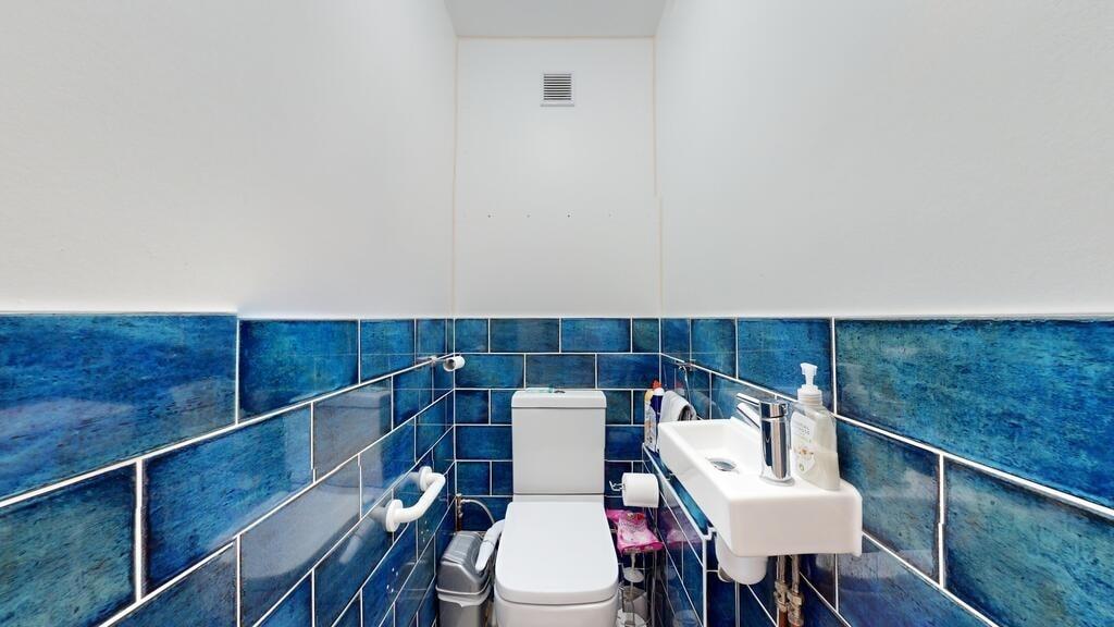 Compact but well-maintained bathroom with blue ...