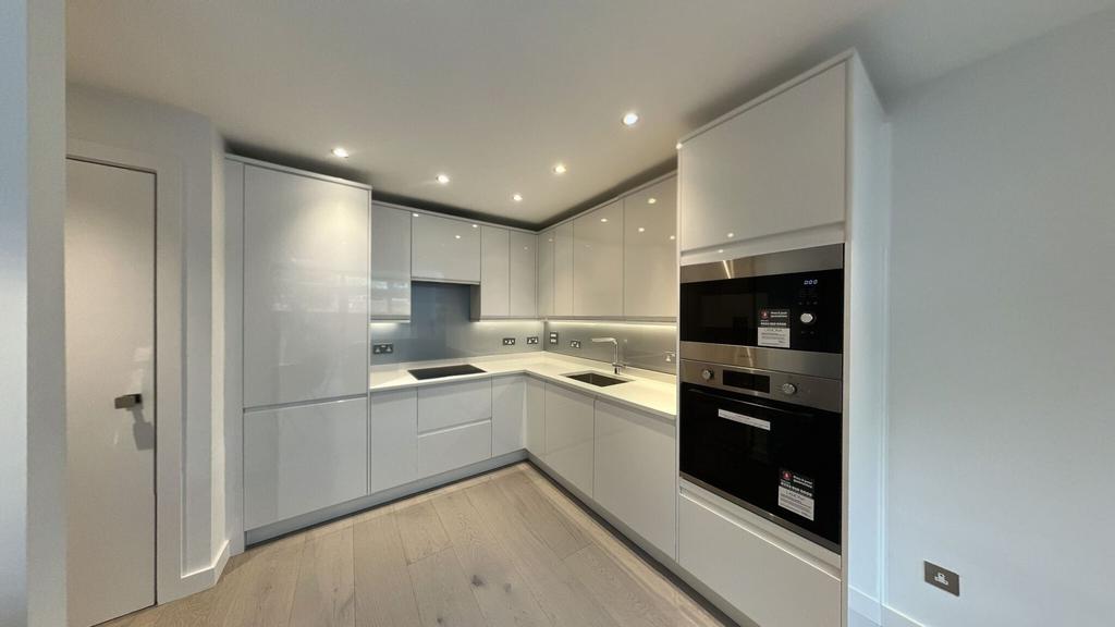 Modern and sleek kitchen with glossy white cabi...
