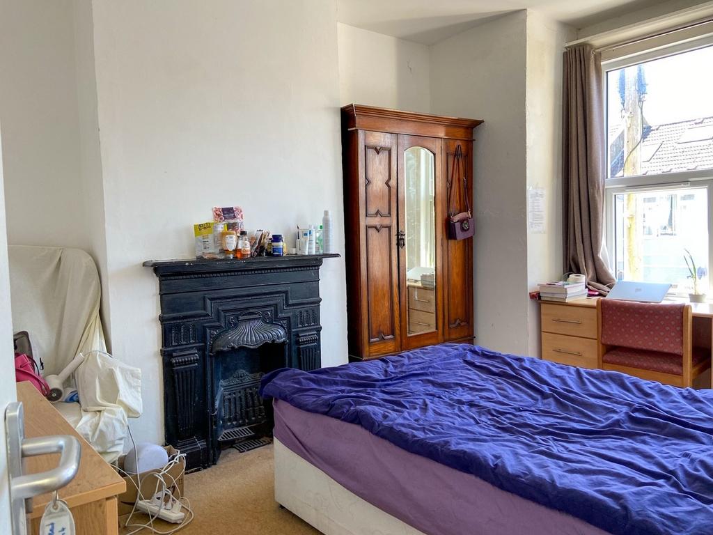 A cozy bedroom featuring a bed with a purple du...