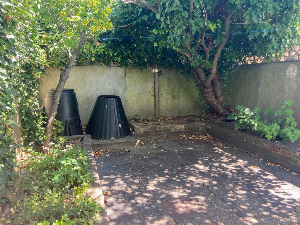 Private paved garden area with mature trees pro...