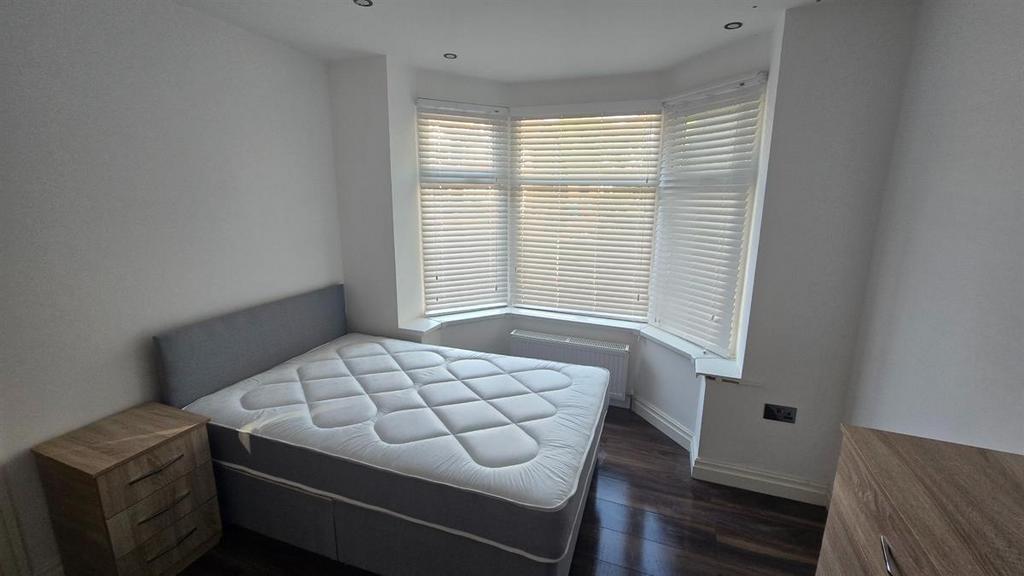 A bright and tidy bedroom featuring a comfortab...