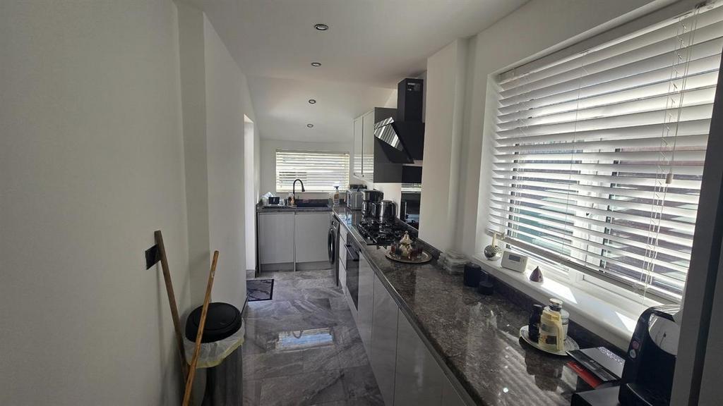 A modern and well-lit kitchen with ample worksp...