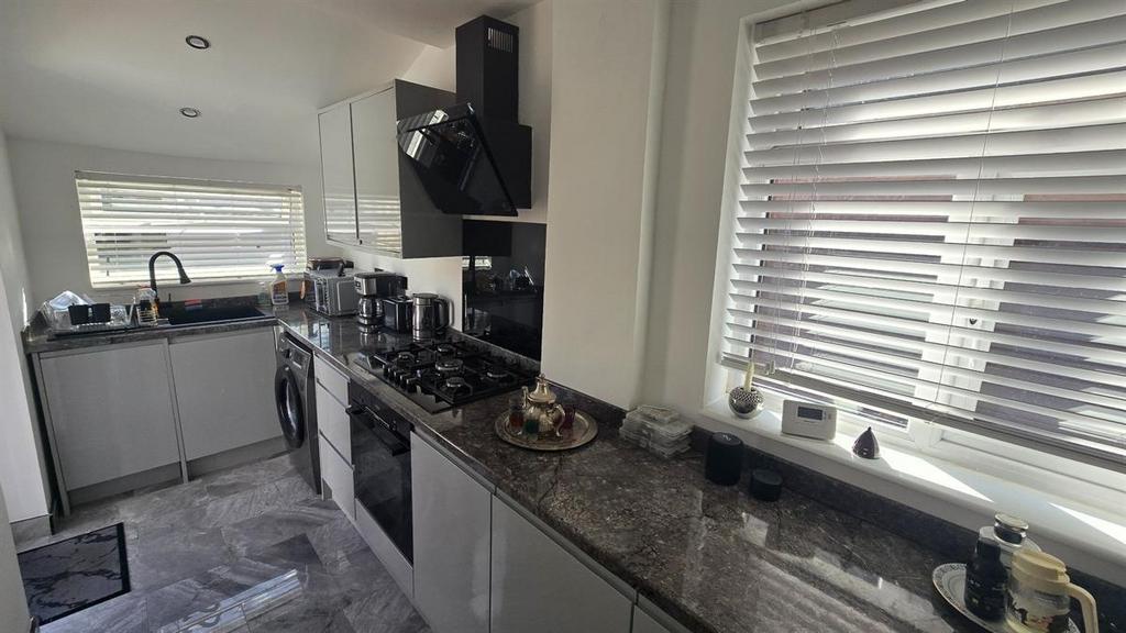 A modern kitchen with a sleek countertop, stain...