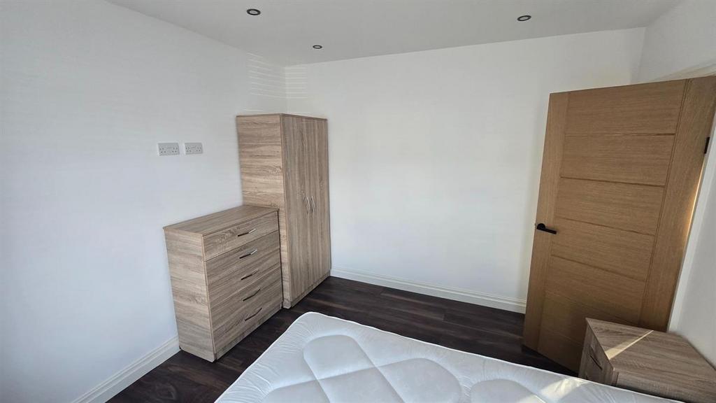 A well-maintained bedroom featuring a wooden fi...