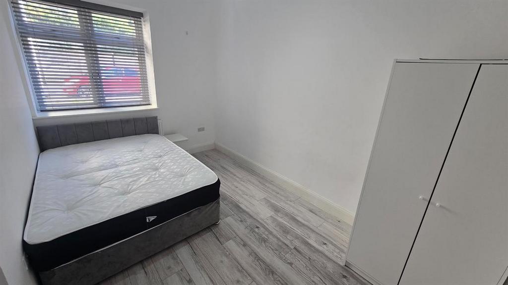 A clean and bright small bedroom with a window ...