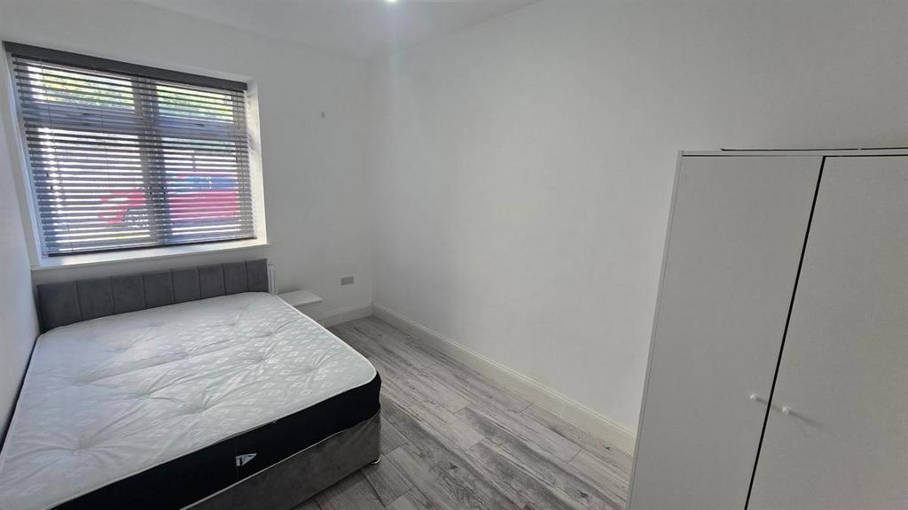 A bright and tidy student bedroom featuring a d...