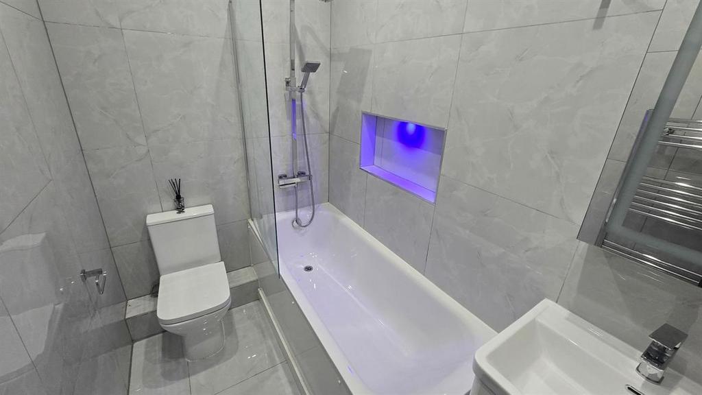 A modern and clean bathroom featuring a bathtub...