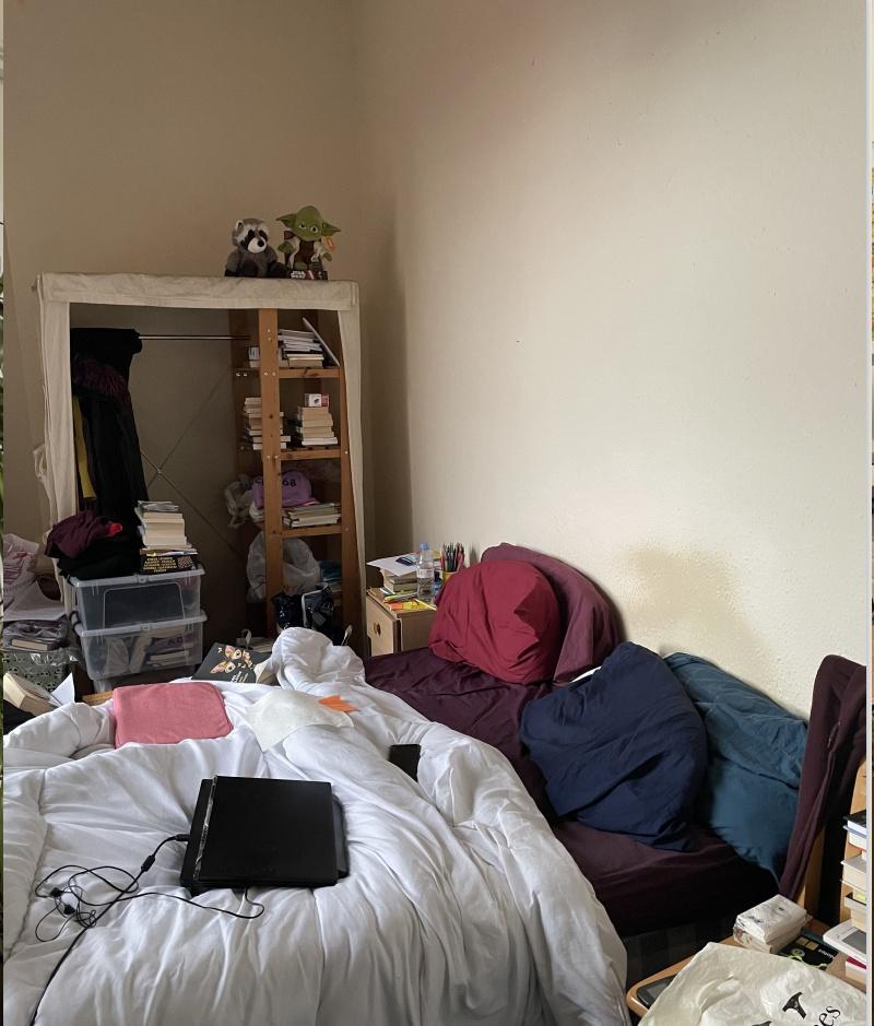 A cozy bedroom with a bed, featuring visible cl...