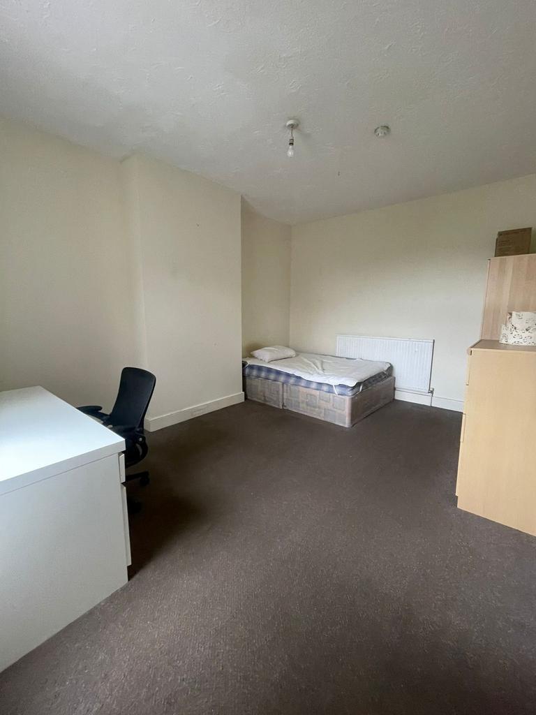A modest single bedroom featuring a single bed,...