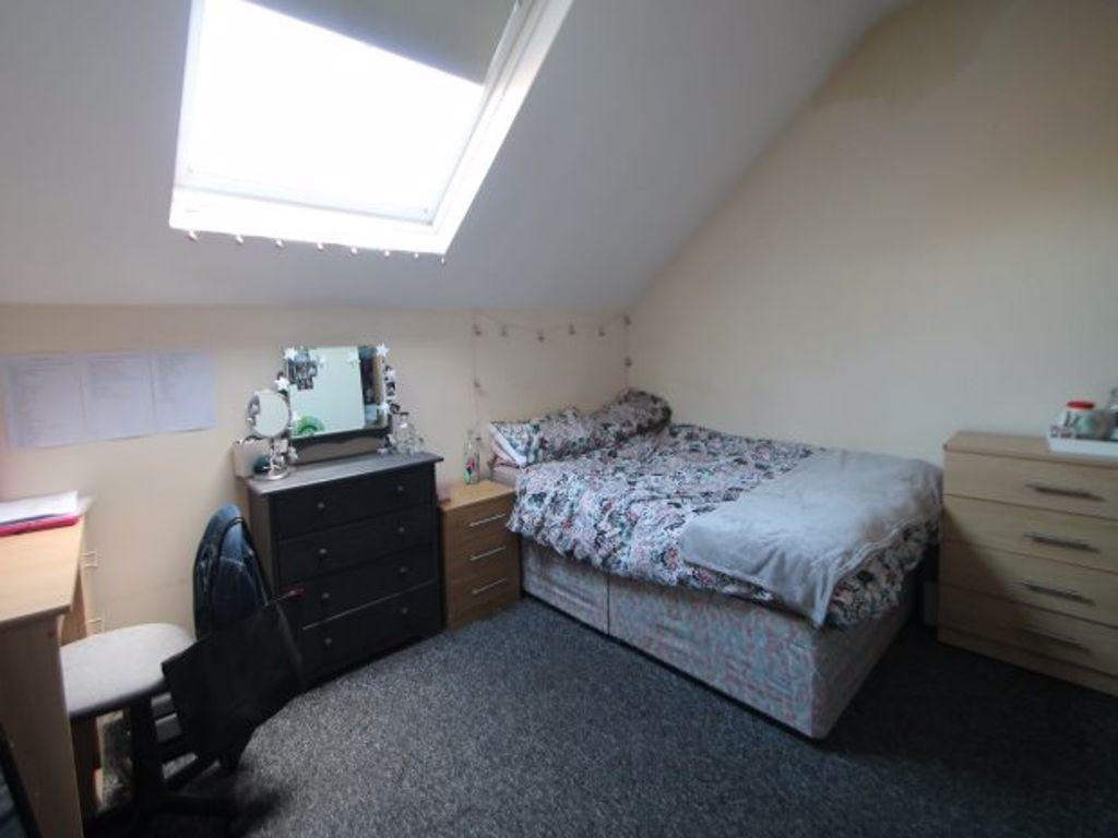A cozy bedroom with a single bed, fitted wardro...