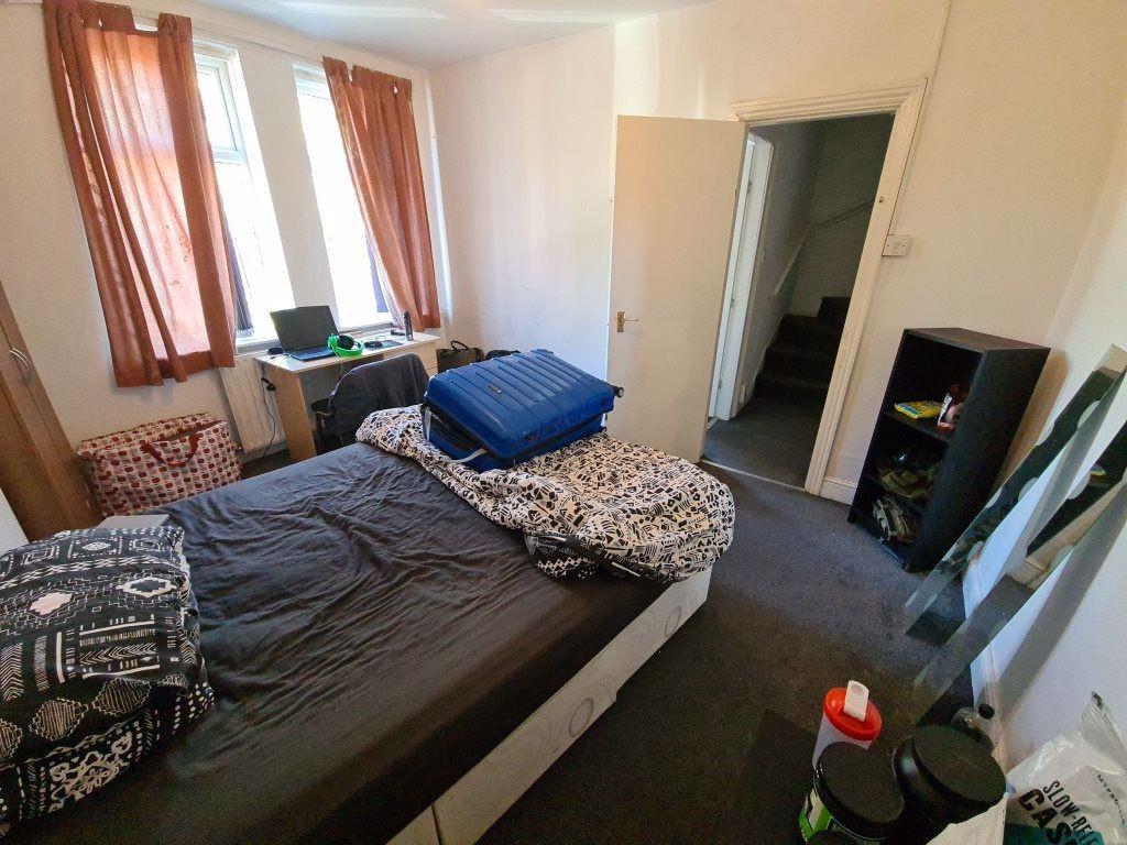 A well-lit bedroom with a double bed, providing...