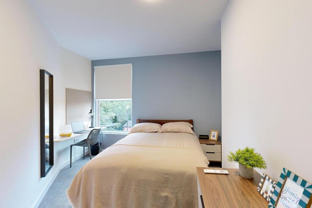 A tidy and bright single bedroom featuring a co...