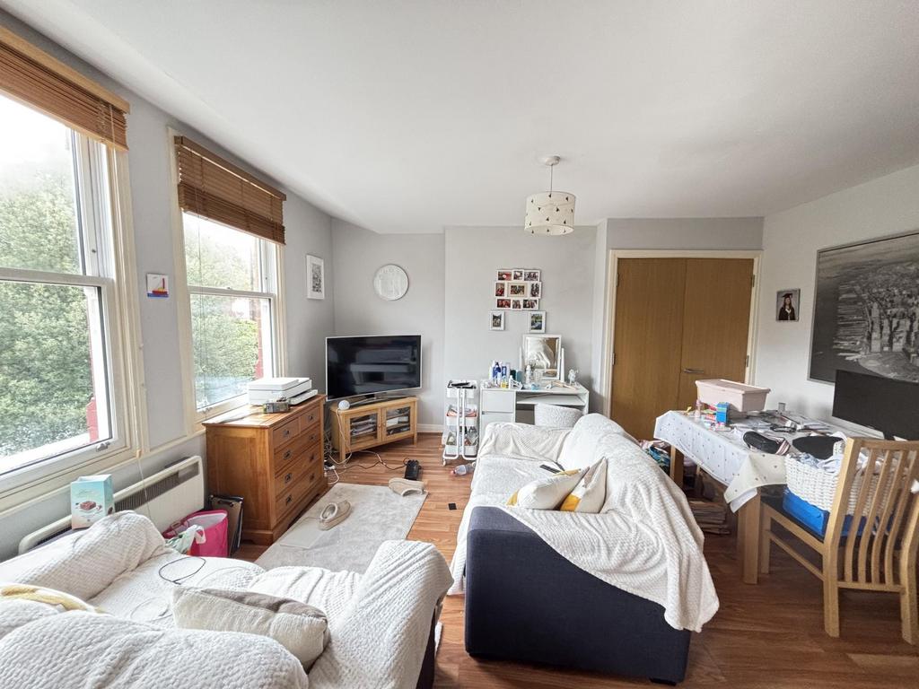 A spacious, bright living room filled with natu...