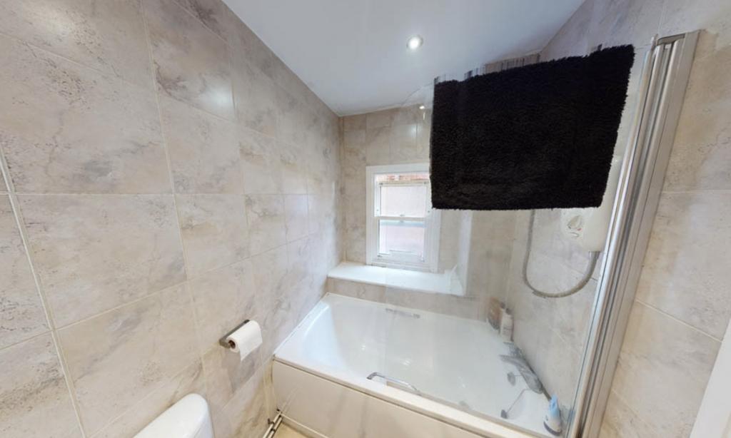 A well-maintained bathroom featuring a bathtub ...