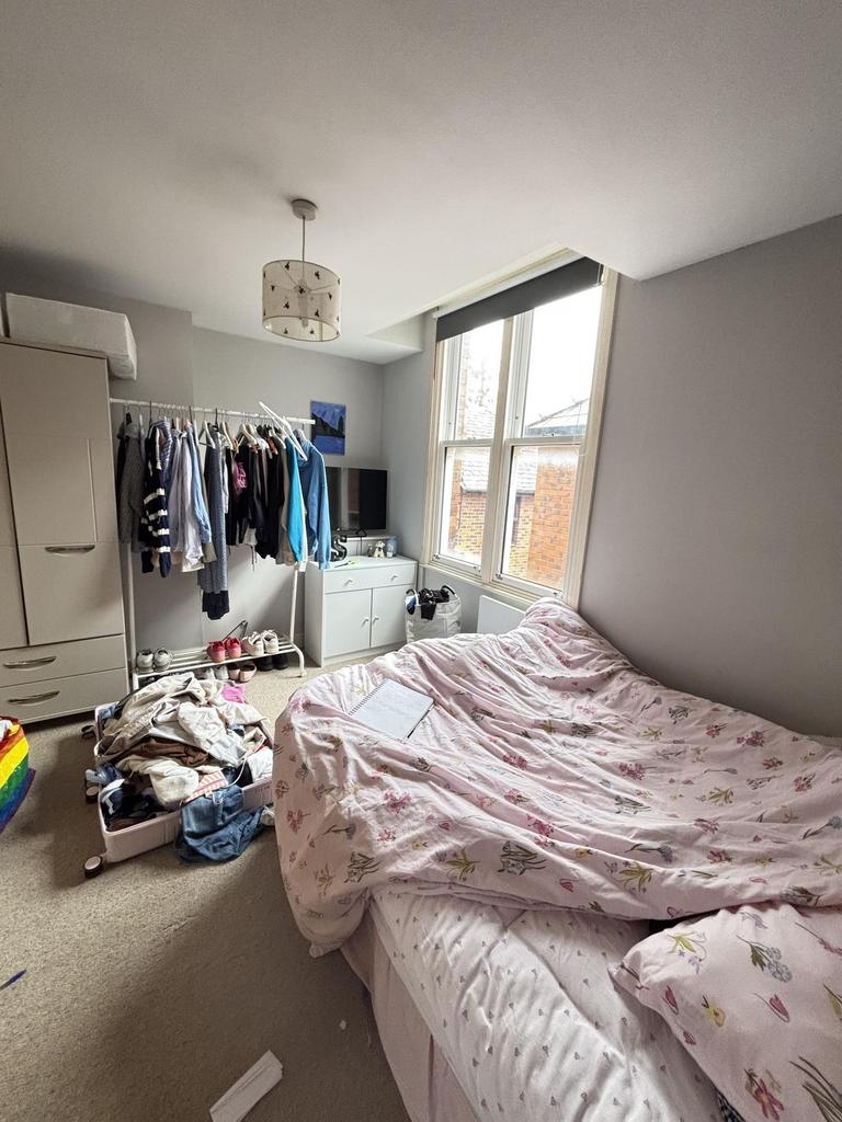 A small, lived-in bedroom featuring a double be...