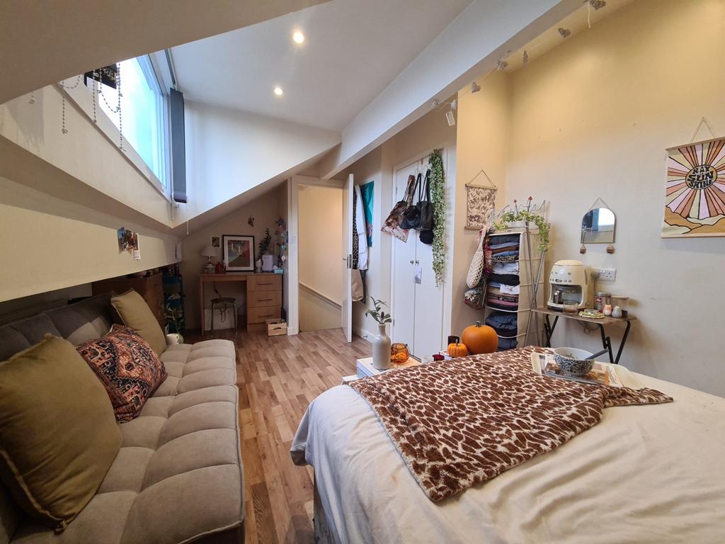 A bright, well-lit bedroom featuring a comforta...