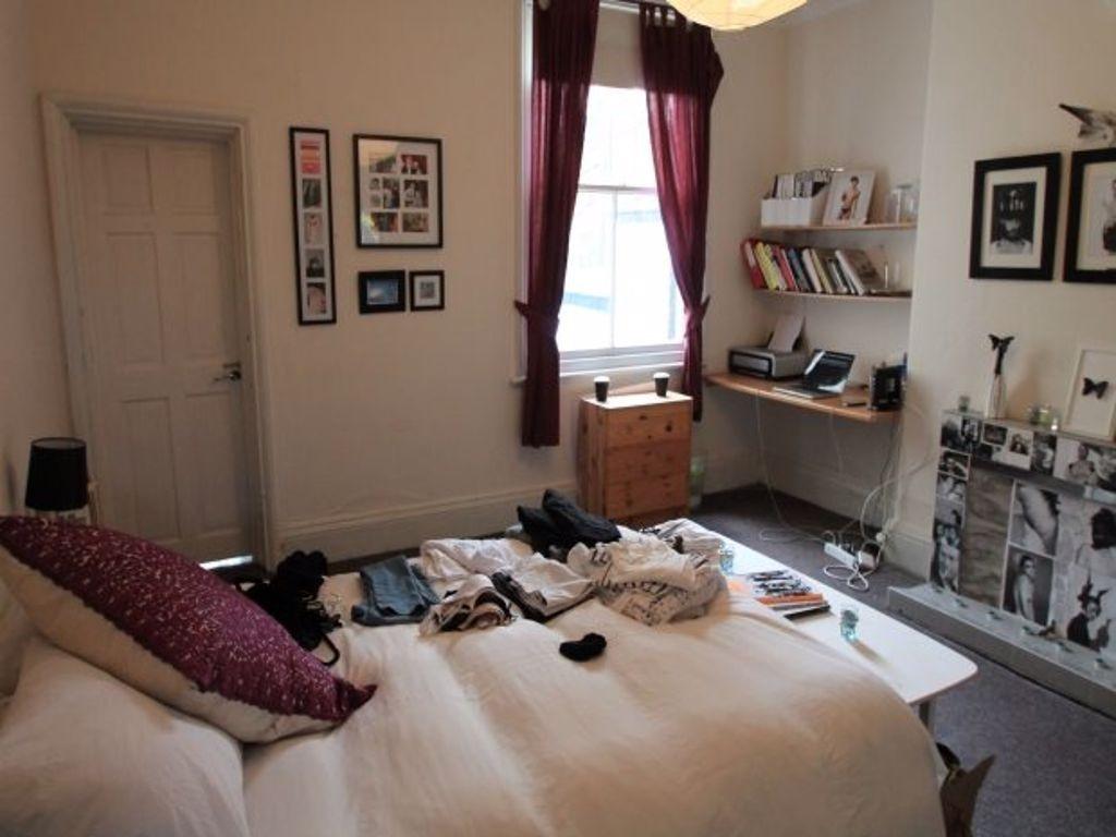 A well-lit bedroom featuring a cozy double bed ...