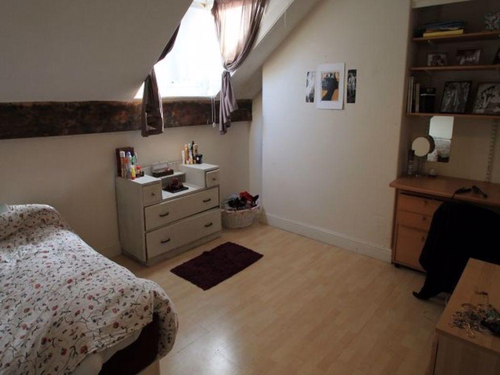 A cozy single bedroom featuring a bed with flor...