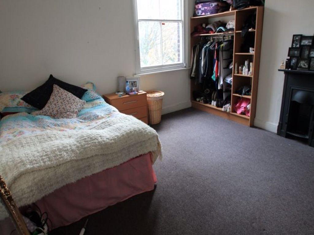 A cozy bedroom featuring a comfortable bed with...