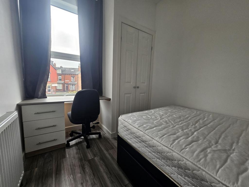 A bright and tidy student bedroom featuring a s...
