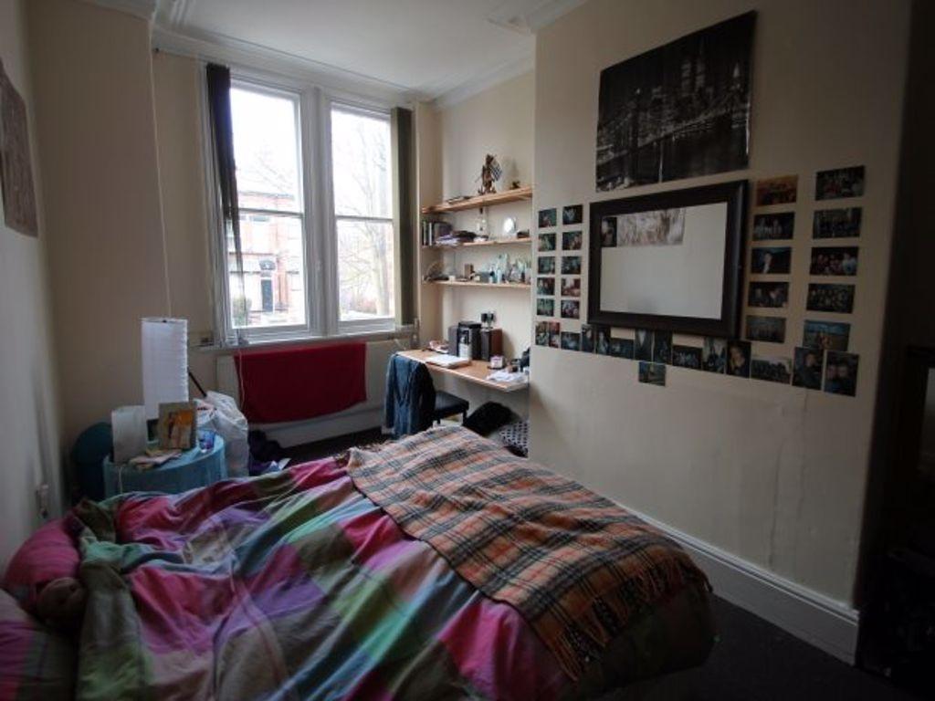 A cozy bedroom featuring a neatly made bed with...